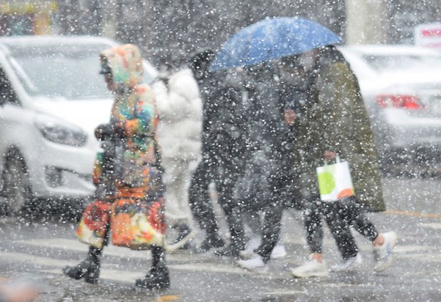 눈 내리는 광주 17일 광주 동구 금남로에서 시민들이 우산으로 쏟아지는 눈을 막으며 길을 가고 있다. 이날 광주와 전라 지역에 이어 18일에는 중부 내륙 지역에 함박눈이 내릴 것으로 예보됐다. 광주=뉴시스