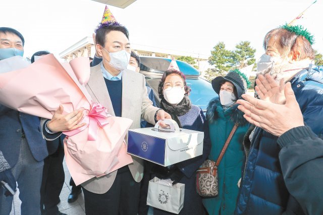 생일 축하받는 윤석열 18일 생일을 맞은 국민의힘 윤석열 대선 후보가 서울 여의도 국회 의원회관 앞에서 지지자들로부터
 꽃다발과 케이크를 받고 있다. 윤 후보는 지지자들에게 “지난해에도 환갑날 꽃을 보내주셨다. 내가 환갑날 징계를 먹었다”고 
말했다. 지난해 검찰총장이던 윤 후보는 정직 2개월의 징계를 받은 바 있다. 뉴스1