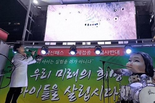 산부인과 전문의 A 씨가 13일 서울 강남 백신패스 반대 집회에 참석해 백신 실험 결과 미생물이 나왔다며 영상을 공개하고 있다. / 사진 = 온라인 커뮤니티 캡쳐