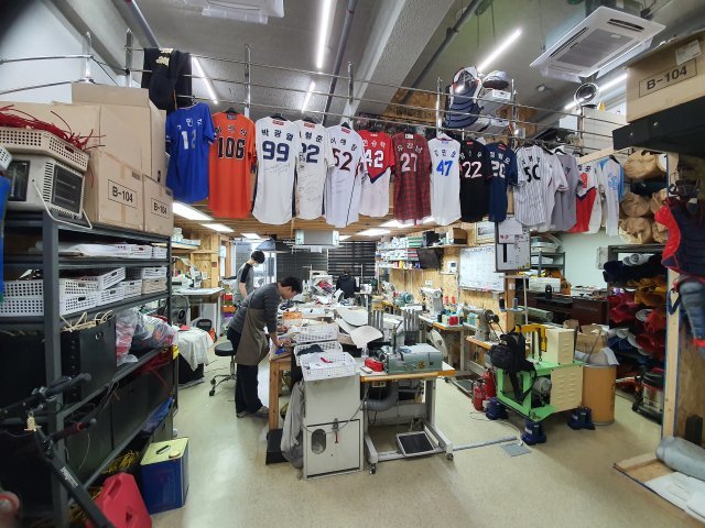 원에이티 글러브 공장 전경. 복층 난간에는 그간 후원해온 선수들의 유니폼이 걸려있다.