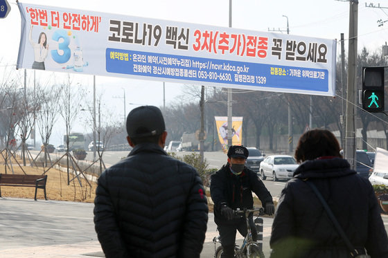 국내 신종 코로나바이러스 감염증(코로나19) 확진자가 이틀째 7000명대을 넘어서며 방역에 비상이 걸린 가운데 9일 경북 경산시내 한 횡단보도 위에 코로나19 백신 3차(추가)접종 독려 캠페인 현수막이 붙어 있다. 2021.12.9/뉴스1 © News1