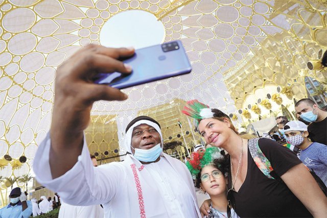 아랍에미리트 건국 50주년 기념일인 2일(현지 시간) 두바이의 한 전시장에서 국기 모양을 머리에 장식한 사람들이 스마트폰으로 자신들의 모습을 찍고 있다. 두바이=AP 뉴시스