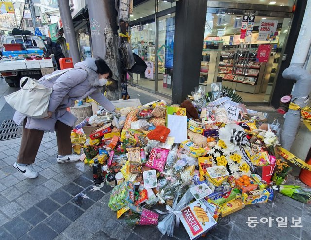 22일 부산 수영팔도시장 입구에서 발생한 교통사고로 60대 할머니와 18개월 손녀가 사망한 가운데 사고 현장에 추모의 발걸음이 이어지고 있다. 25일 한 시민이 추모 물품을 놓고 있다. 부산=김화영 기자 run@donga.com