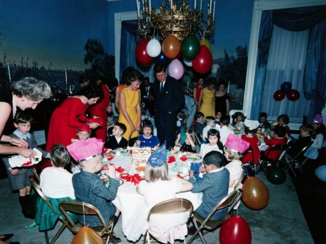 1962년 자녀들을 위해 마련한 백악관 생일 파티에서 존 F 케네디 대통령(가운데)이 어린이들이 노는 모습을 지켜보고 있다. 존 F 케네디 대통령 도서관