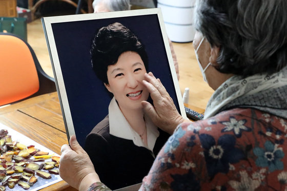 박근혜 전 대통령에 대한 특별 사면 소식이 전해진 24일 오후 대구의 한 경로당에서 할머니가 박 전 대통령 존영을 어루만지고 있다. 2021.12.24/뉴스1 © News1