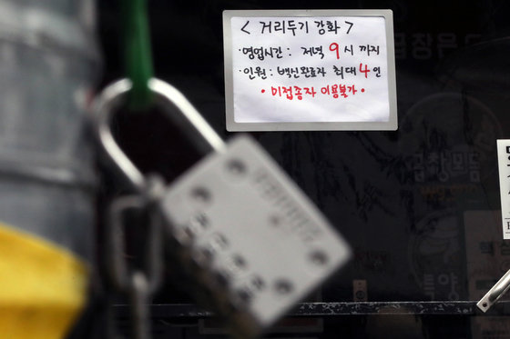 서울 서대문구 신촌 먹자골목의 한 식당에 ‘거리두기 강화’를 알리는 안내문이 붙어있다./뉴스1 © News1
