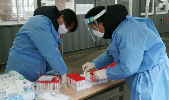 서울 중구 서울역광장에 마련된 신종 코로나바이러스 감염증(코로나19) 임시선별진료소에서 의료진이 검체 키트를 준비하고 있다. © News1