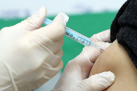 지난 27일 오후 서울 은평구 청구성심병원에서 한 시민이 코로나19 백신 3차접종을 하고 있다.  © News1