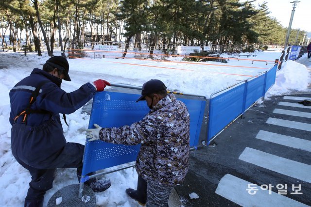 전국 자치단체들이 코로나19 확산을 우려해 동해안을 비롯한 지역 주요 새해 일출 명소를 폐쇄하기로 한 31일 오후 강원 속초시 속초해변 주변에 관계자들이 출입 통제 펜스를 설치하고 있다.