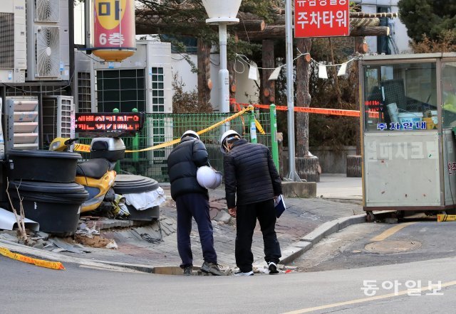 지난해 12월 31일  경기 고양시 마두역 인근 건물 앞에서 국토안전관리원 사고조사위원회와 고양시 공무원들이 푹꺼진 도로와 인도를 살펴보고 있다. 고양=전영한 기자 scoopjyh@donga.com