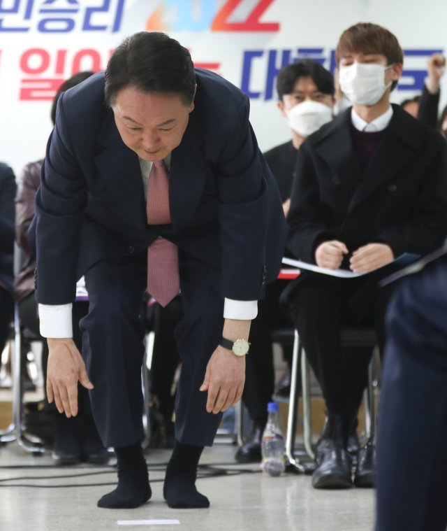 국민의힘 윤석열 대선 후보가 지난 1일 서울 여의도 대하빌딩에서 열린 국민의힘 선대위 신년인사회에서 구두를 벗고 예정에 없던 큰절을 하고 있다. 뉴시스