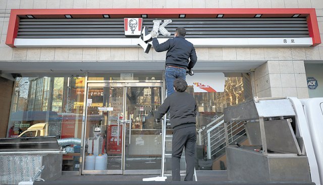 3일 오전 서울 종로구 KFC 종로점에서 철거 작업자들이 간판을 내리고 있다. 뉴시스