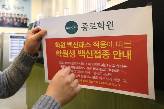4일 오후 서울 마포구 종로학원 강북본원에서 관계자가 방역패스 관련 안내문을 떼고 있다.2022.1.4/뉴스1 © News1