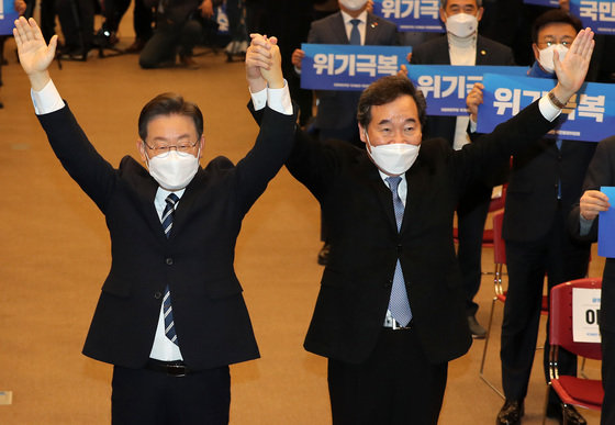 이재명 더불어민주당 대선후보와 이낙연 전 대표가 5일 오전 광주 서구 김대중컨벤션센터에서 열린 ‘국가비전·국민통합위원회 첫 번째 비전회의’에서 함께 팔을 들어올리고 있다. 2022.1.5/뉴스1 © News1