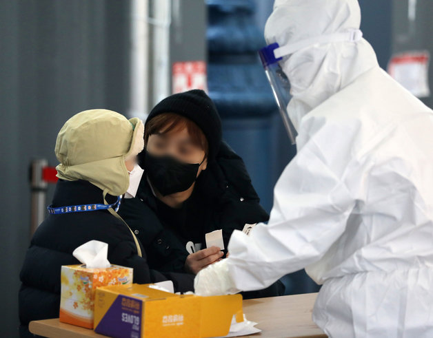 5일 오전 서울 중구 서울역광장에 마련된 선별진료소를 찾은 어머니와 아이가 검체 검사를 받고 있다. 2022.1.5/뉴스1 © News1