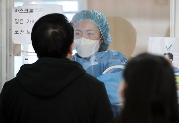 6일 오전 서울 중구 서울역광장에 마련된 선별진료소에서 의료진이 검체검사를 하고 있다. 코로나19 장기화와 확진자 폭증에 따른 업무 과부하로 의료 현장의 업무기피, 휴직 등 이탈현상이 심화되는 가운데 서울시와 25개 자치구는 코로나19 방역 최일선에서 장기간 격무에 시달리는 전담 인력 1250명에게 1인당 400만원씩 포상금을 지급하기로 했다. 지급 대상은 간호·보건 공무원으로 자치구별 50명, 총 1250명 규모의 7급 이하 실무 공무원들이다. 근무시기에 따라 올해 1월 또는 6월에 포상한다.2022.1.6/뉴스1 © News1