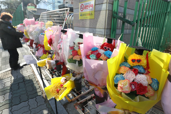 6일 졸업식이 열린 대구의 한 중학교 교문 앞에서 꽃을 파는 노점상이 꽃다발을 진열하고 있다. 2022.1.6/뉴스1