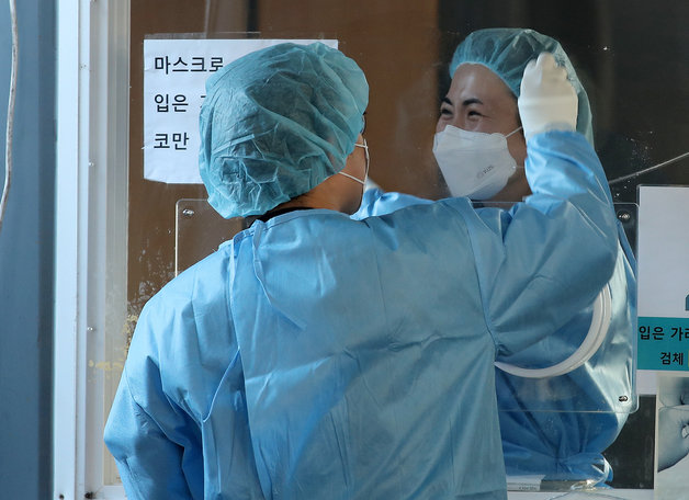 6일 오전 서울 중구 서울역광장에 마련된 선별진료소에서 의료진이 미소를 지으며 검사 준비를 하고 있다.  © News1