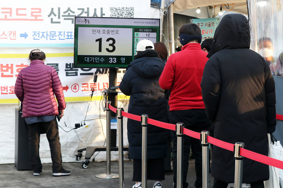 10일 오전 서울 중구 서울역광장에 마련된 임시 선별검사소를 찾은 시민들이 번호표를 받고 줄을 서 검사 차례를 기다리고 있다. 2022.1.10/뉴스1 © News1