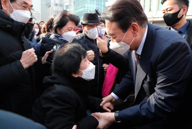 국민의힘 윤석열 대선후보가 10일 인천광역시 중구 인천역 앞에서 산업화 교역일번지 인천지역 공약을 발표한 뒤 한 지지자의 손을 잡아주고 있다. 사진공동취재단