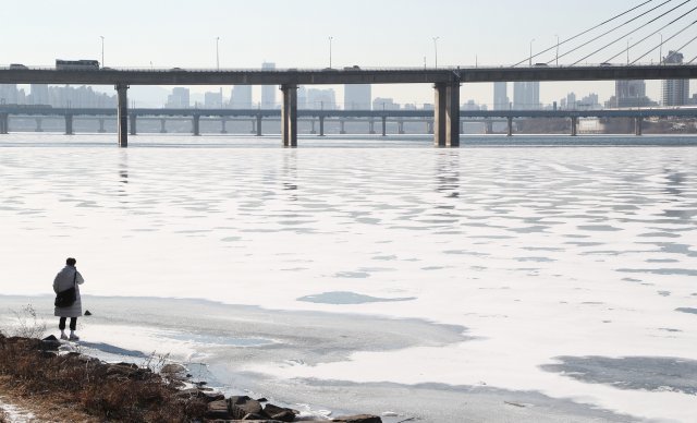 11일 서울의 최저기온이 영하 10도까지 떨어지고, 바람이 불며 체감온도는 더 떨어졌다. 기상청은 12일 서울의 아침 최저기온은 영하 12도까지 떨어지는 등 이번주 내내 영하의 추위가 계속될 것으로 예보했다. 한 시민이 얼음 언 한강 모습을 찍고있다.