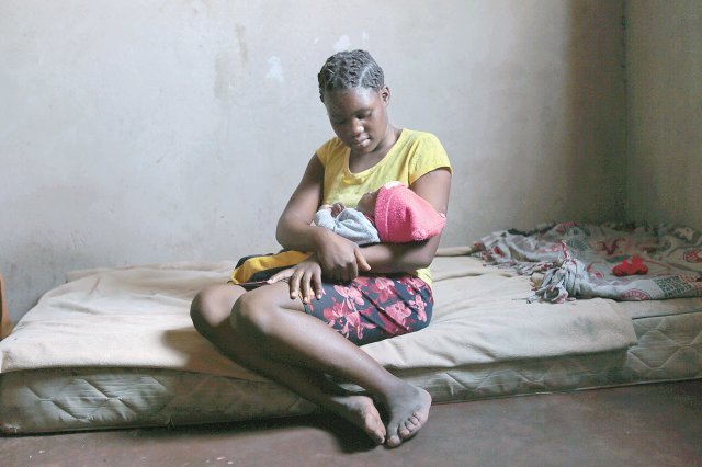 올해 13세인 버지니아 마브훙가가 짐바브웨의 한 시골마을에 있는 자신의 집에서 생후 3개월 된 아들을 안고 있다. 짐바브웨 등 
일부 아프리카 국가에서는 코로나19 사태로 집에 머무는 동안 성폭력을 당해 임신한 뒤 학업을 중단하는 10대 여성들이 급증하고 
있다. 무레와=AP 뉴시스