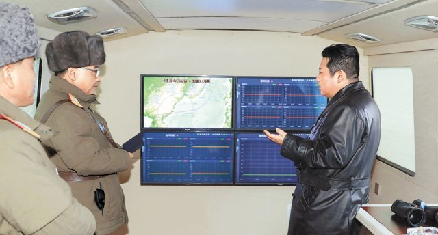 북한이 14일 탄도미사일 추정 발사체를 쐇다. 사진은 김정은 북한 국무위원장(오른쪽)이 11일 극초음속미사일 시험 발사를 참관하면서 모니터를 보는 모습. 평양=AP 뉴시스