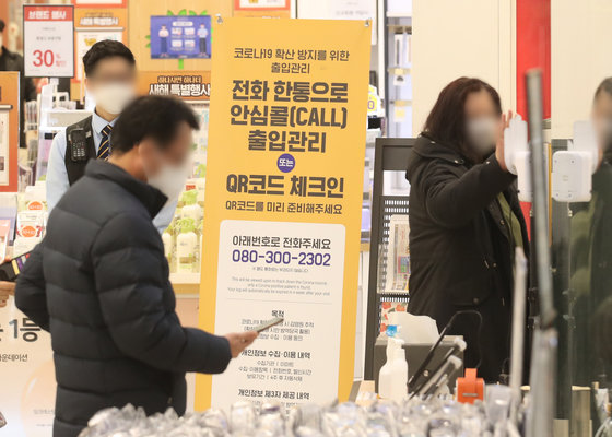 서울 내의 3천㎡ 이상 상점·마트·백화점에 적용한 방역패스 조치의 효력 정지 결정이 나온 가운데 16일 서울 한 대형마트에서 시민들이 QR코드 체크를 하고 있다. 2022.1.16/뉴스1 © News1