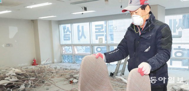 18일 김정규 쌤인테리어철거 대표가 지난해 12월 폐업한 경기 수원시의 독서실에서 의자를 옮기고 있다. 수원=김재명 기자 base@donga.com