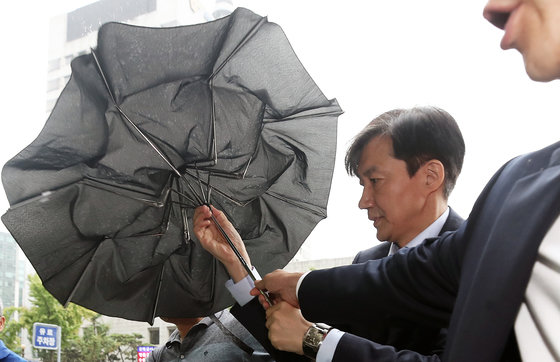2019년 8월 29일 당시 조국 법무부 장관 후보자가 서울 종로구에 마련된 청문회 준비 사무실로 출근하며 우산을 접고 있다.  © News1