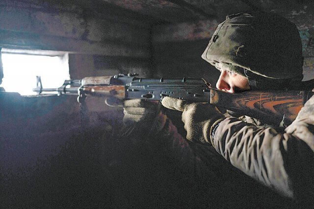 20일(현지 시간) 우크라이나 루간스크주 졸로테의 러시아 접경지역에 배치된 우크라이나 병사가 바깥을 향해 소총을 겨누고 있다. 사진 출처 게티이미지코리아