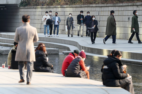 7일 서울 종로구 청계천에서 점심식사를 마친 시민들이 따뜻한 날씨를 즐기며 산책을 하고 있다. 2021.12.7/뉴스1