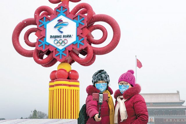 중국 베이징에서 관광객들이 2022 베이징 겨울올림픽 조형물 앞에서 마스크를 쓴 채 기념사진을 찍고 있다. 중국은 신종 코로나바이러스 감염증(코로나19) 확산과 미국 등의 외교적 보이콧 등으로 긴장된 분위기 속에서 올림픽 개막을 준비하고 있다. 베이징=AP 뉴시스