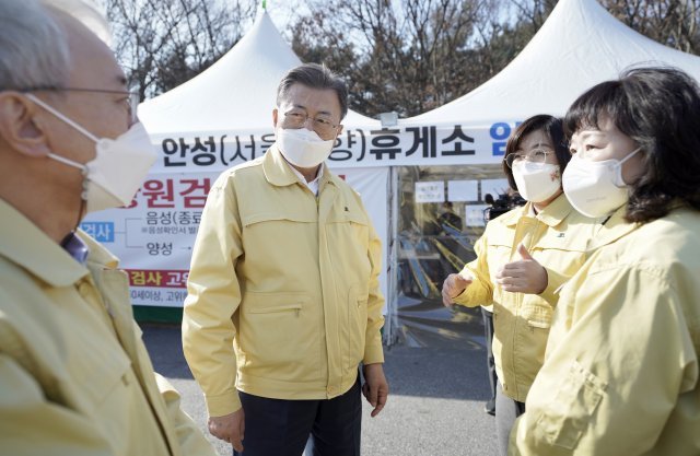 문재인 대통령이 설 연휴인 30일 오후 경기도 안성휴게소(서울방향)에 마련된 코로나19 임시 선별검사소를 방문해 김보라 안성시장 및 정혜숙 안성시 보건소장으로부터 현황 보고를 받고 있다. 청와대사진기자단