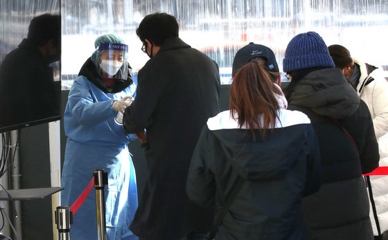 설 연후 첫날인 29일 오전 서울 중구 서울역광장에 마련된 신종 코로나바이러스 감염증(코로나19) 임시선별진료소에서 의료진이 시민들을 안내하고 있다.2022.1.29/뉴스1 © News1