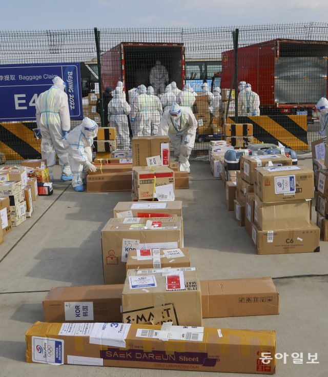베이징공항에서 활주로에 옮겨 놓은 수화물을 방역복을 입은 관계자들이 트럭으로 옮기고 있다. 원대연 기자 yeon72@donga.com