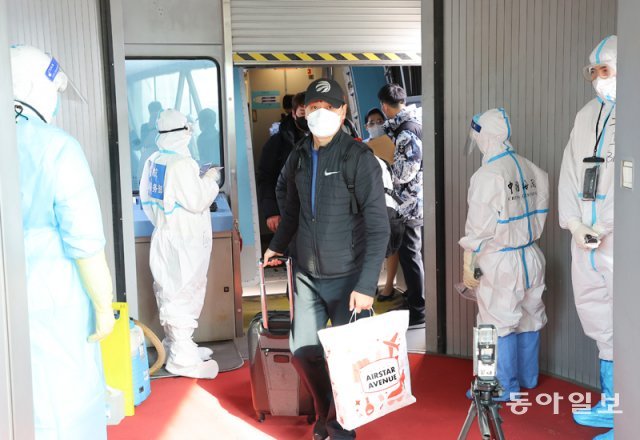 베이징 공항에 도착한 올림픽 한국팀 관계자들 안내를 위해  방역복을 입은 공항요원이 항공기 문 앞에서 기다리고 있다. 원대연 기자 yeon72@donga.com