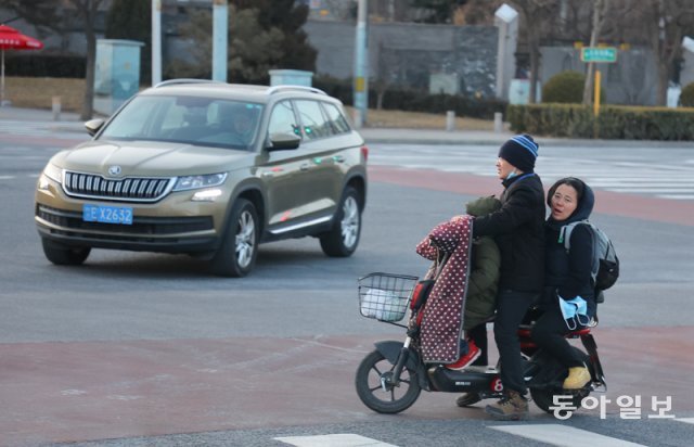 베이징 시내의 시민이 오토바이를 타고 이동하고 있다. 올림픽 기간중 베이징 시내는 오가는 사람이 보이지 않아 삭막하다. 원대연 기자 yeon72@donga.com＞