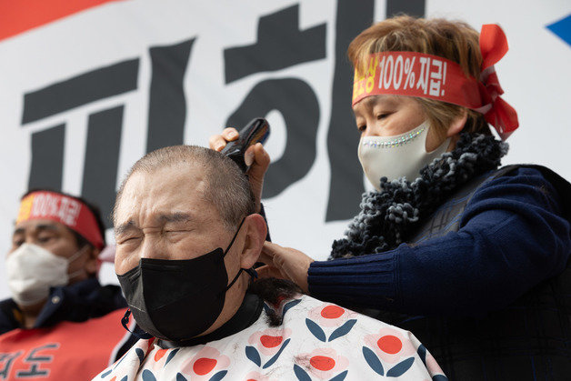 코로나 피해 자영업 총연대 회원들이 25일 오후 서울 여의도 국회 인근에서 열린 ‘분노와 저항의 299인 릴레이 삭발식’에서 삭발을 하고 있다. 2022.1.25/뉴스1 © News1