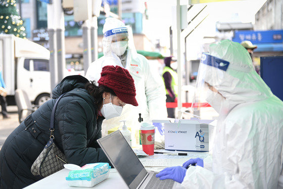25일 경기 여주시 5일장 입구에 설치된 PCR이동검사소에서 상인이 검진표를 작성하고 있다. (여주시 제공)© 뉴스1