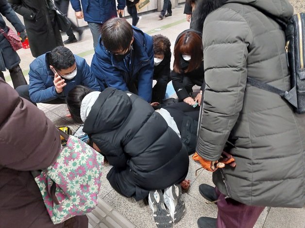 서울 지하철 7호선 노원역에서 의식을 잃고 쓰러진 승객에 응급처치하는 역 직원들과 시민들. ⓒ 뉴스1