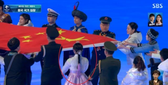 4일 열린 베이징 동계올림픽 개회식에서 한복을 입은 여성이 중국 국기인 ‘오성홍기’를 전달하고 있다. 사진=SBS 중계화면 캡처