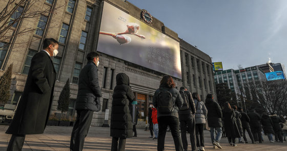 7일 오전 서울 중구 서울도서관 벽면에 새단장된 꿈새김판 ‘겨울은 길었지만 결국, 봄은 옵니다’ 아래로 임시 선별검사소를 찾은 시민들이 길게 줄을 서 검사 차례를 기다리고 있다. 2022.2.7/뉴스1 © News1