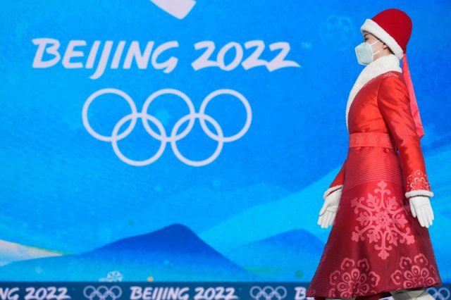 8일 동계올림픽  메달 시상식장에서 한 도우미가 선수를 에스코트하고 있다. 베이징=AP