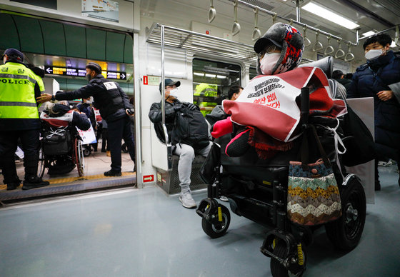 전국장애인차별철폐연대 회원들이 3일 서울 종로구 광화문역에서 장애인권리보장법·장애인탈시설지원법 제정과 기획재정부의 장애인 생존권 예산 확보 등을 촉구하며 기자회견을 마친 뒤 지하철 5호선을 타고 여의도 농성장으로 이동하고 있다. 2022.1.3/뉴스1 © News1