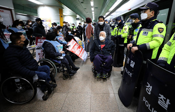 전국 장애인차별철폐연대 회원들이 20일 오전 서울 종로구 지하철 5호선 광화문역에서 장애인 이동권 보장을 촉구하며 공덕역으로 이동하기 위해 집결하고 있다. 2021.12.20/뉴스1