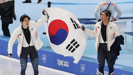 차민규(왼쪽)와 김준호가 12일 오후 중국 베이징 국립 스피드스케이팅 경기장에서 열린 2022 베이징 동계올림픽 스피드스케이팅 남자 500ｍ 경기를 마치고 태극기를 들고 빙판 위를 달리고 있다. 이날 차민규는 은메달을 획득해 2018년 평창에 이어 2연속 은메달을 획득했다. 2022.2.12/뉴스1 © News1