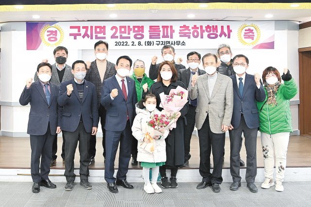 8일 대구 달성군 구지면사무소에서 김문오 달성군수(앞줄 왼쪽에서 세 번째)와 직원들이 인구 2만 명 달성의 주인공인 이현정 씨 가족(앞줄 가운데)에게 축하 꽃다발을 전하고 있다. 대구 달성군 제공