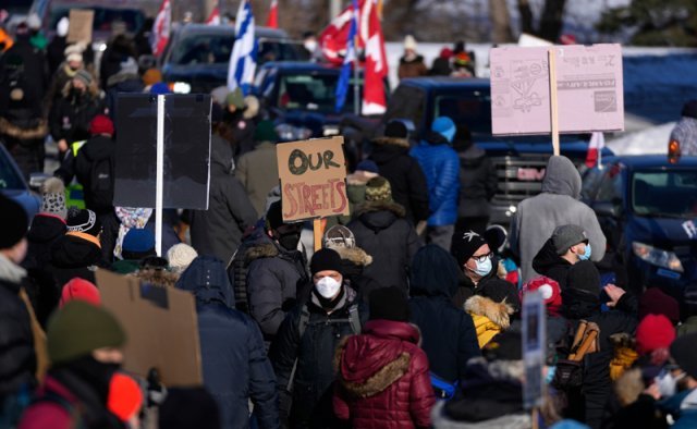 13일(현지시간) 캐나다 오타와 시의회 앞에서 시민들이 코로나19 백신 패스에 반대하는 트럭 운전자들에 반대하는 맞불 시위를 하고 있다. 이들은 17일째 시위 중인 트럭 운전자들의 차량 운행을 막고 주민들에게 일상을 돌려주고 떠나라며 항의했다. 오타와=AP/뉴시스