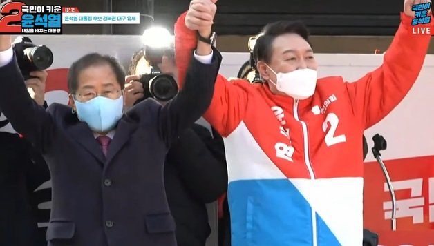 윤석열 국민의힘 대선 후보와 홍준표 의원이 15일 경북 동대구역 앞에 마련된 유세차량에서 손을 맞잡고 만세를 부르고 있다.(국민의힘 공식 유튜브채널 오른소리 갈무리)© 뉴스1